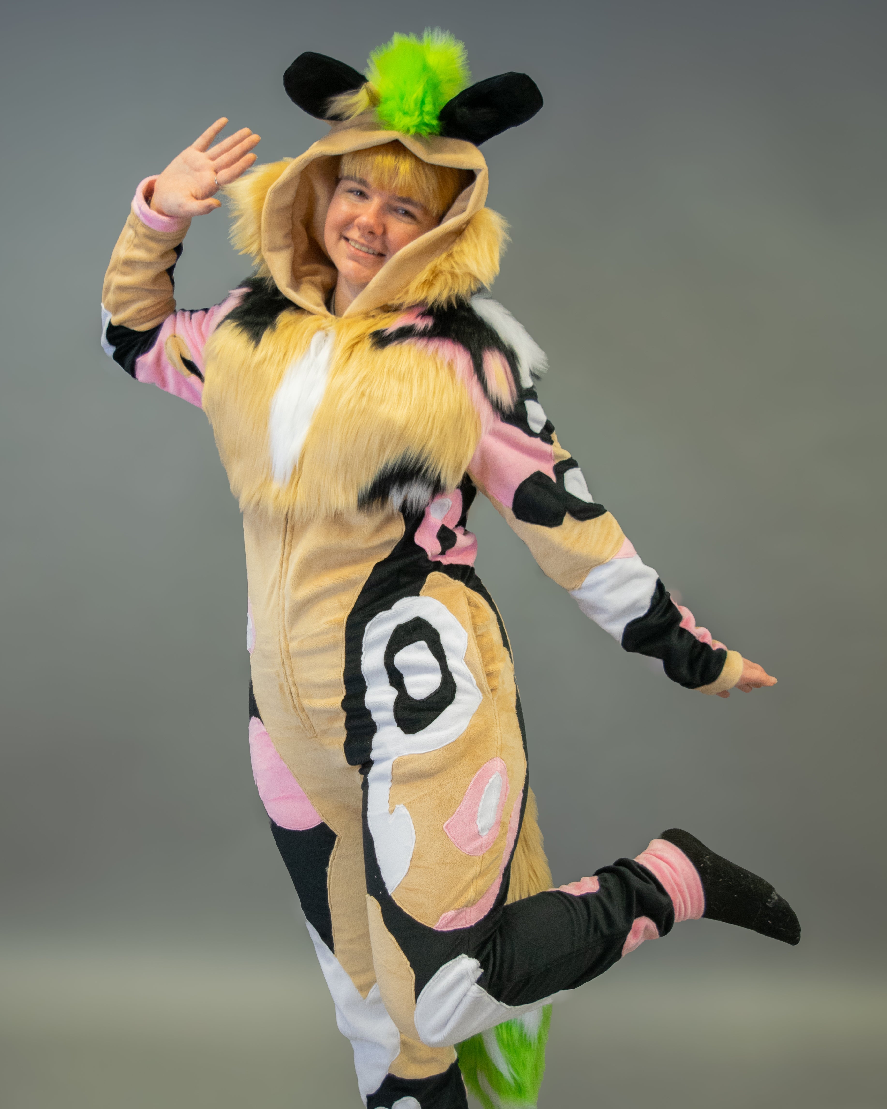 Person wearing a colorful animal-themed onesie against a gray background